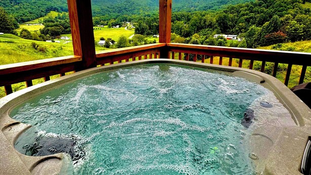 A hot tub with a view of a green landscape and mountains. - Fox Run Log Cabin~ LUXE~Asheville~Dutch Cove (Canton)