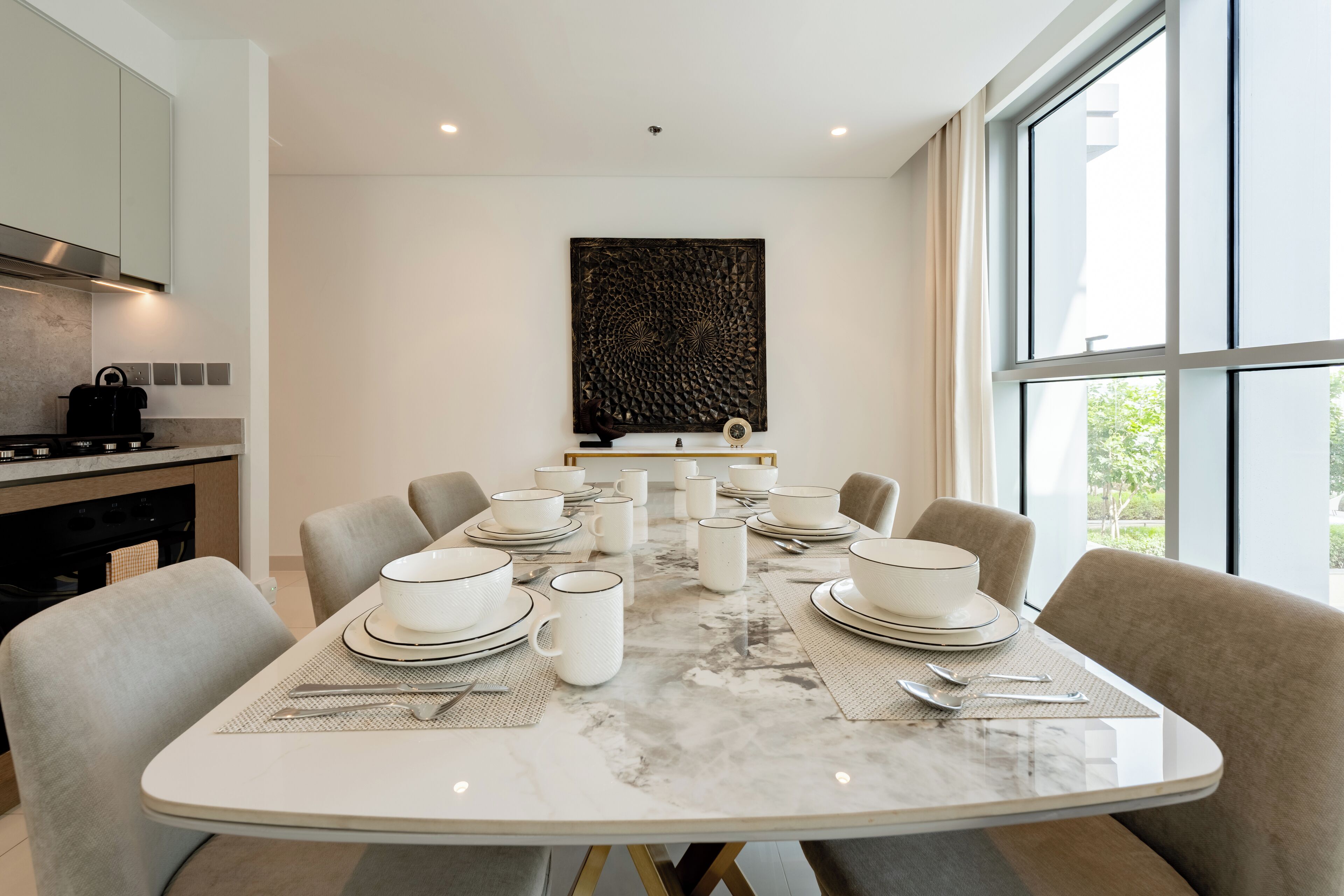 A modern dining room with a marble table set for six, surrounded by six chairs.