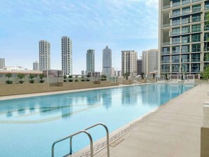 Una piscina con el horizonte de la ciudad al fondo.