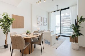 Uma sala de jantar moderna com uma mesa redonda, cadeiras e plantas em vasos.