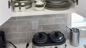 A kitchen with white cabinets, a gray backsplash, and stainless steel appliances. - Beautiful Renovated Bi-level  Home close to shopping, transit, & Rec Centre (Calgary)