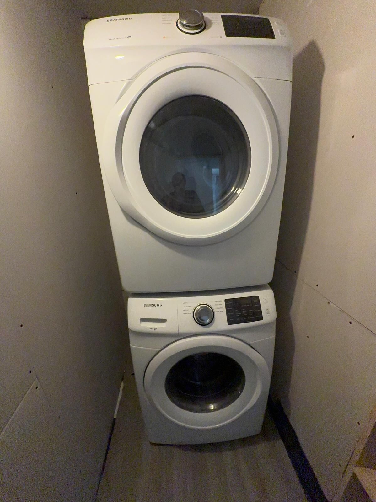 A stacked washer and dryer unit in a laundry room.
