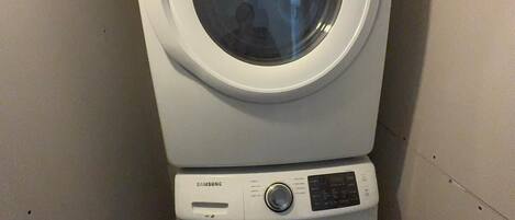 A stacked washer and dryer unit in a laundry room.