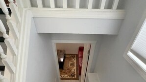 A staircase with white balusters leading to a landing. - Beautiful Renovated Bi-level  Home close to shopping, transit, & Rec Centre (Calgary)