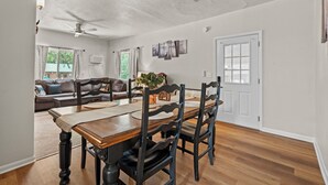 A dining area with a wooden table, black chairs, and a ceiling fan. - Timber Lodge Cabins 32 (Colorado Springs)