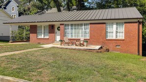 A single-story brick house with a front porch, two windows, and a door. - From the Square to Ole Miss: Historic Oxford Home (Oxford)
