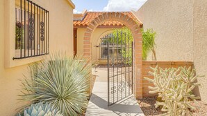 A courtyard with a gate, a small archway, and cacti. - Quiet Townhome w/ Mountain Views in Green Valley (Green Valley)