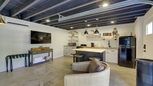 A modern kitchen with a bar area, white cabinetry, and a black refrigerator. - Unique Studio on Obanyon Creek in Dtwn Loveland! (Loveland)