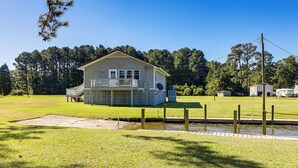 A small, single-story house with a porch, located next to a body of water. - Private Boat Ramp see explanation below (Aurora)