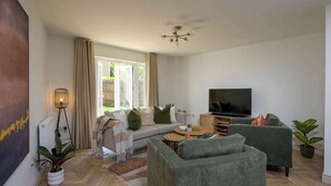 Uma sala de estar moderna com um sofá, uma televisão e uma mesa de centro.