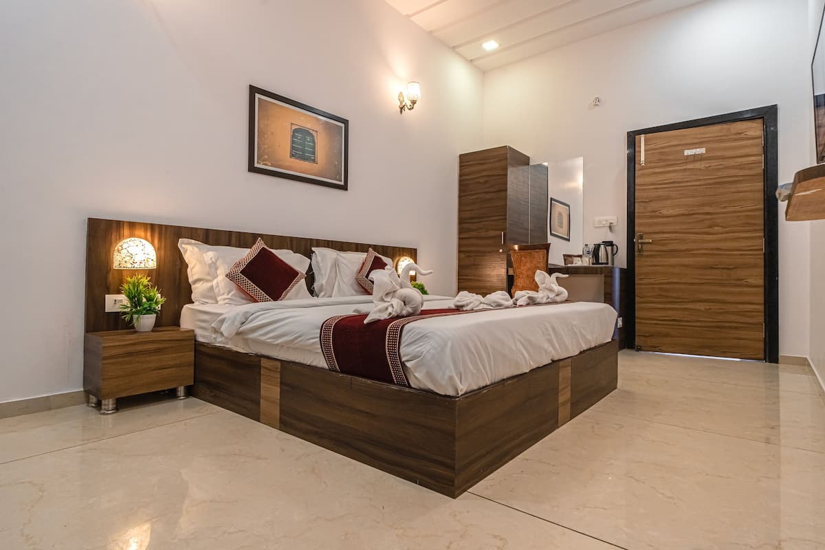Un dormitorio moderno con cama de madera, una mesita de noche con lámpara, una obra de arte en la pared y un armario de madera.