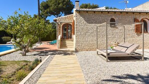 A stone building with a pool, a lounge chair, and a pathway leading to the entrance. - Casa Montana 4 pax - Javea, Costa Blanca (Javea)