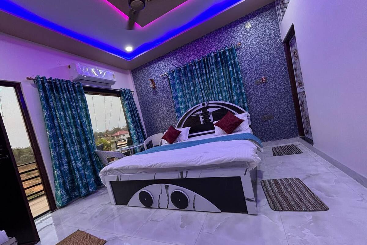 A modern bedroom with a bed, curtains, and a view through a glass door.