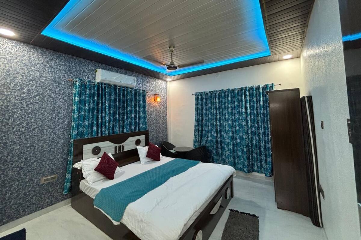 A modern bedroom with a bed, curtains, a ceiling fan, and a wardrobe.