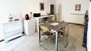Una cocina compacta con una mesa y sillas, un refrigerador y un microondas.