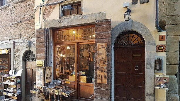 Un edificio tradizionale con una porta in legno e una vetrina piena di oggetti.