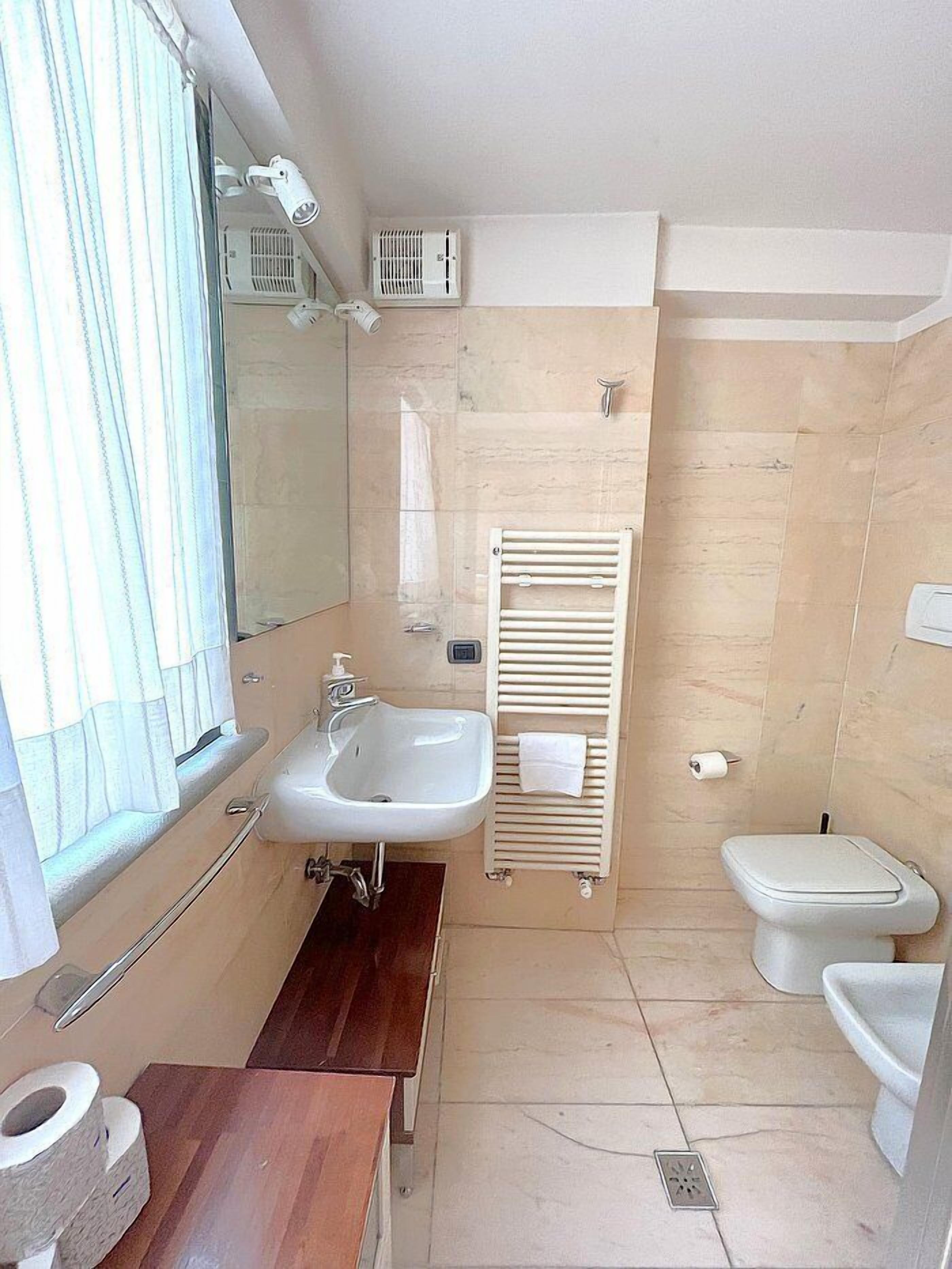Un baño pequeño con lavamanos, inodoro y ducha.