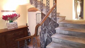 A grand staircase with ornate metal railings and stone steps, leading to an upper floor. - Appartamento Vasaria B: A graceful studio apartment located in the historic center of Arezzo, with Free WI-FI. (Arezzo)