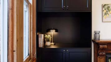A dark wooden cabinet with a small table and a lamp.