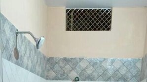 A small bathroom with a toilet, sink, and shower. - Sankatha Guest House (Varanasi)