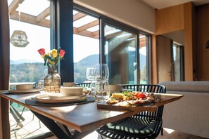 A dining table with a meal, a vase with flowers, and a view of the outdoors. - The Valley Resort (Vama Buzăului)