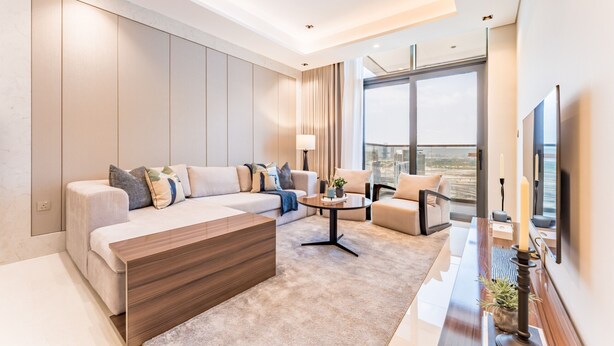 A modern living room with a sofa set, a coffee table, and a TV mounted on the wall. - Spacious High-Floor 2BR with Stunning City and Burj Khalifa Views (Dubai)