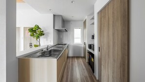 Una cocina moderna con una isla central, electrodomésticos de acero inoxidable y suelo de madera.