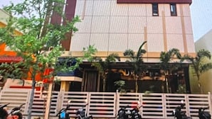 A multi-story building with a textured facade, a flat roof, and a gated entrance. - White Ridge Hotel - Nagole (Hyderabad)
