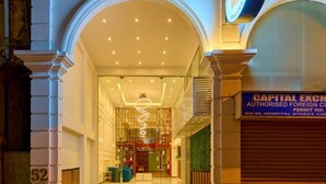 En imponerande entré med en skylt för Capital Exchange, utformad i en klassisk arkitektonisk stil med valv och kolonner.