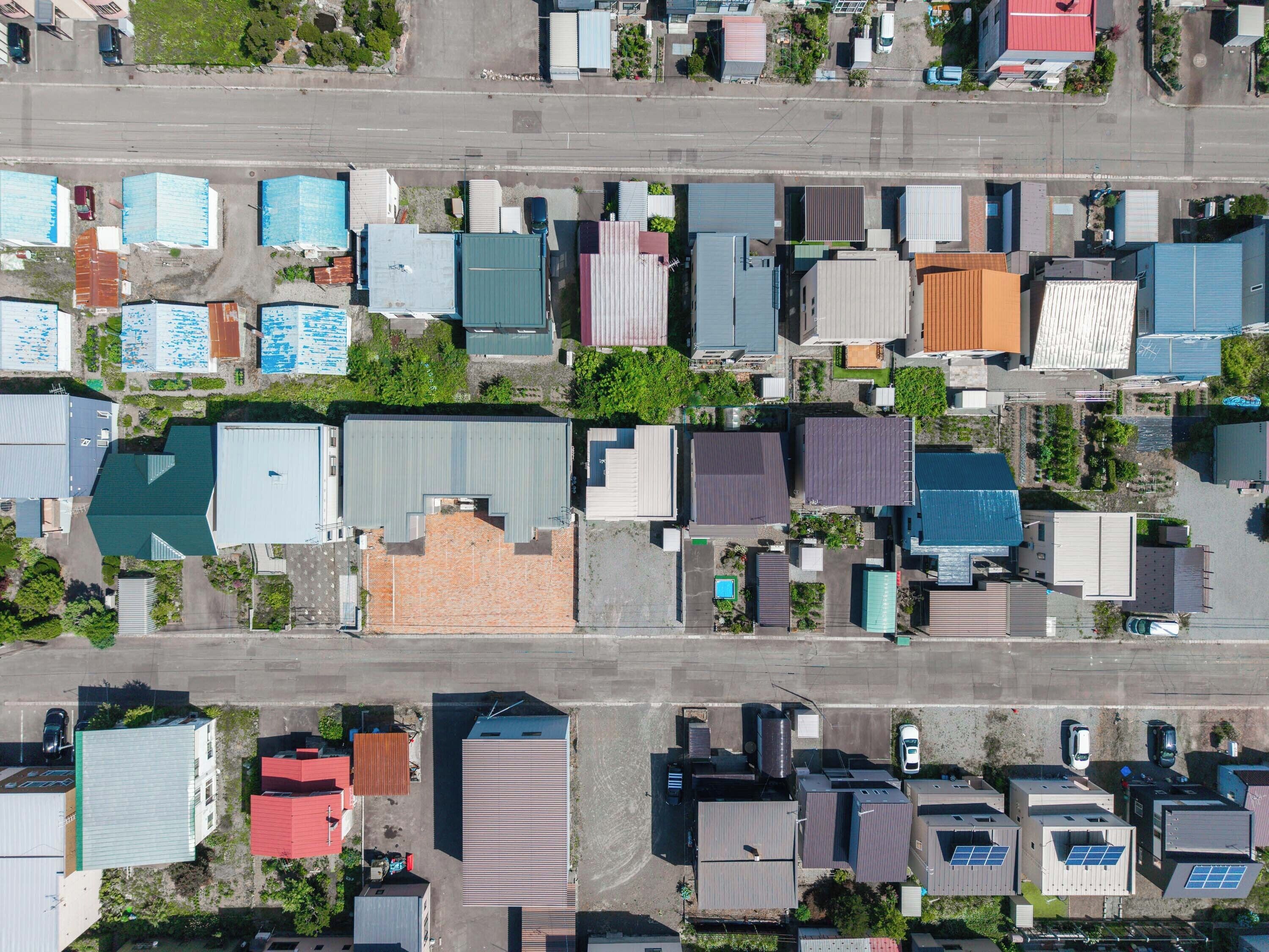 An aerial view of a residential area with various buildings, including houses and commercial structures.