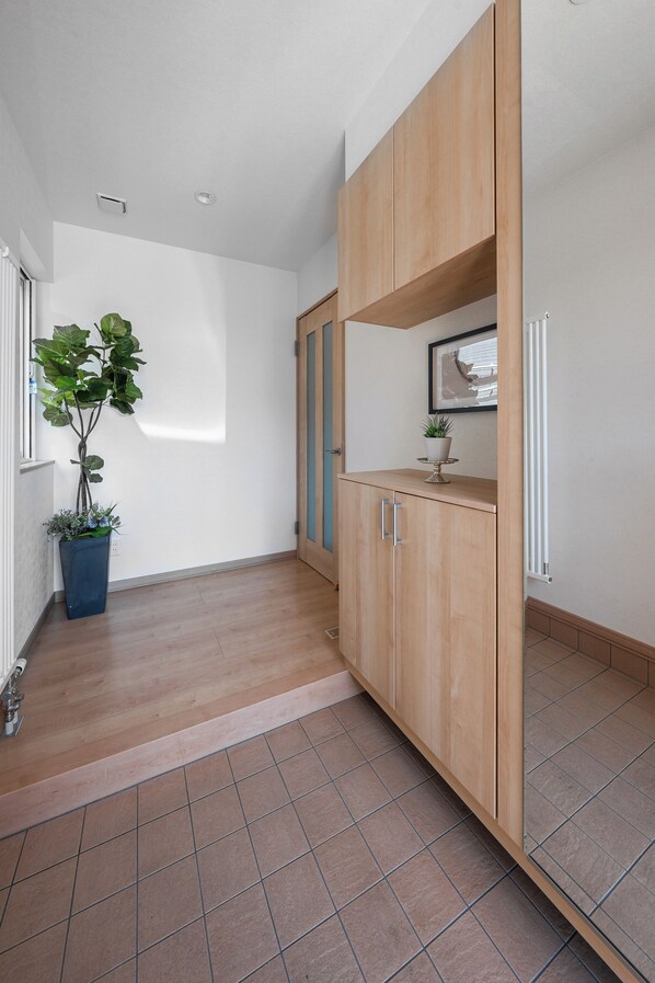 A hallway with wooden cabinets, a potted plant, and a radiator.