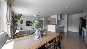 A modern kitchen with wooden cabinets, a built-in oven, and a refrigerator. - THE VERTEX (Asahikawa)