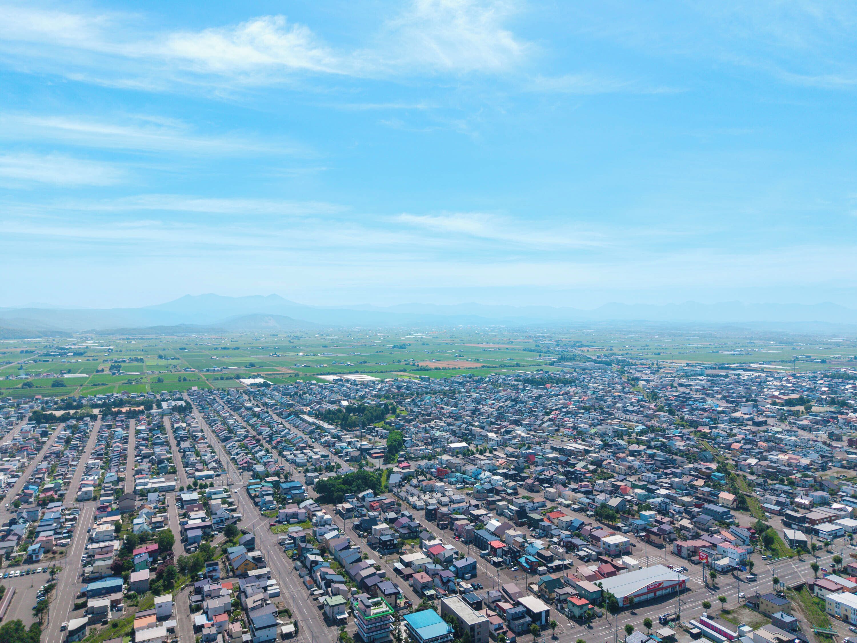 An aerial view of a densely populated urban area with a grid-like street layout and numerous buildings.