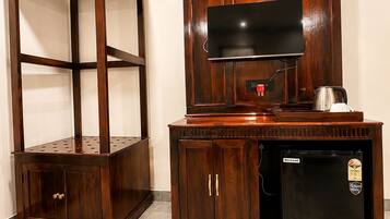 Un mueble de madera con un televisor y un refrigerador pequeño.