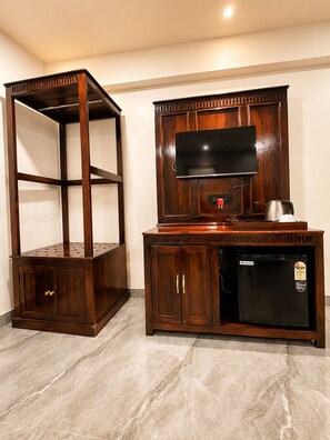 A wooden cabinet with a television and a small refrigerator. - Grand Valley - A boutique Resort in Mount Abu (Mount Abu)