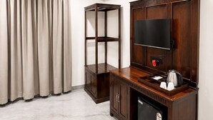 A hotel room with a flat-screen TV, a coffee machine, and a minibar. - Grand Valley - A boutique Resort in Mount Abu (Mount Abu)