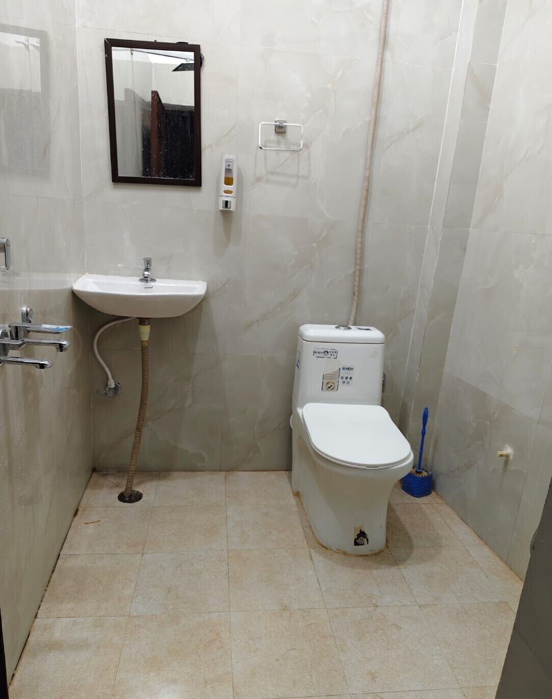 A small bathroom with a white sink, toilet, and a mirror on the wall.