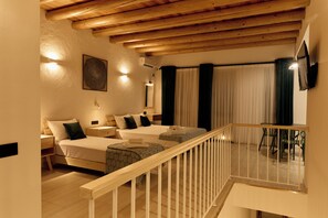 A hotel room with two beds, a wooden ceiling, a balcony with a railing, and a dining area with chairs. - saada boutique studios (Bukhara)