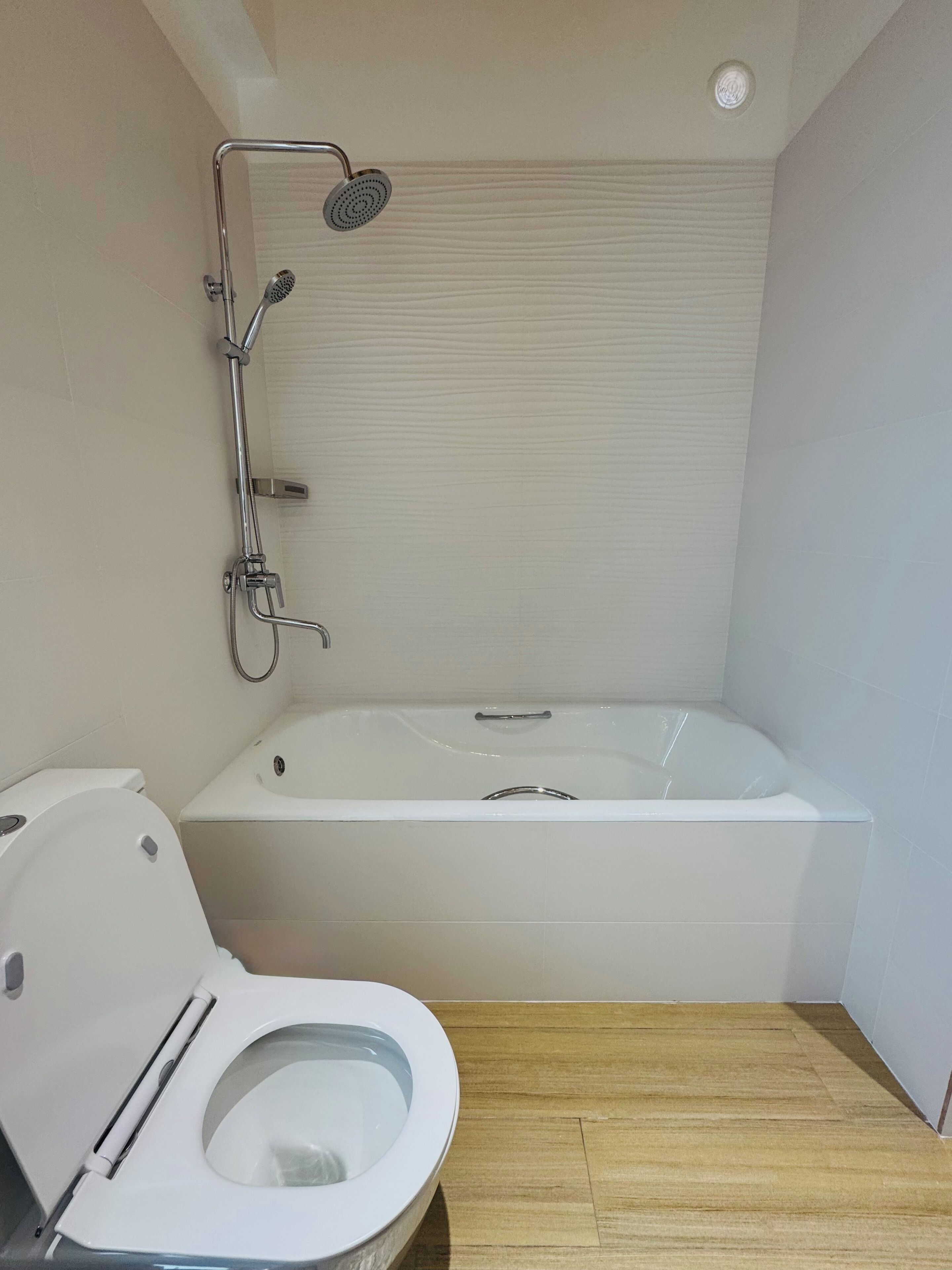 Een badkamer met toilet, douche en bad.