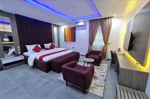 Una habitación de hotel moderna con una cama grande, un escritorio y una zona de estar.