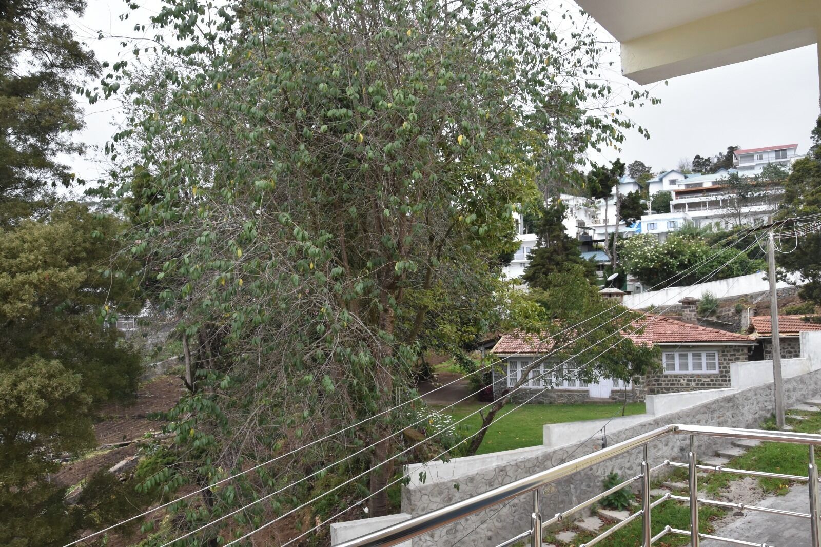 A residential area with a staircase leading to a building with a stone facade and a red-tiled roof.