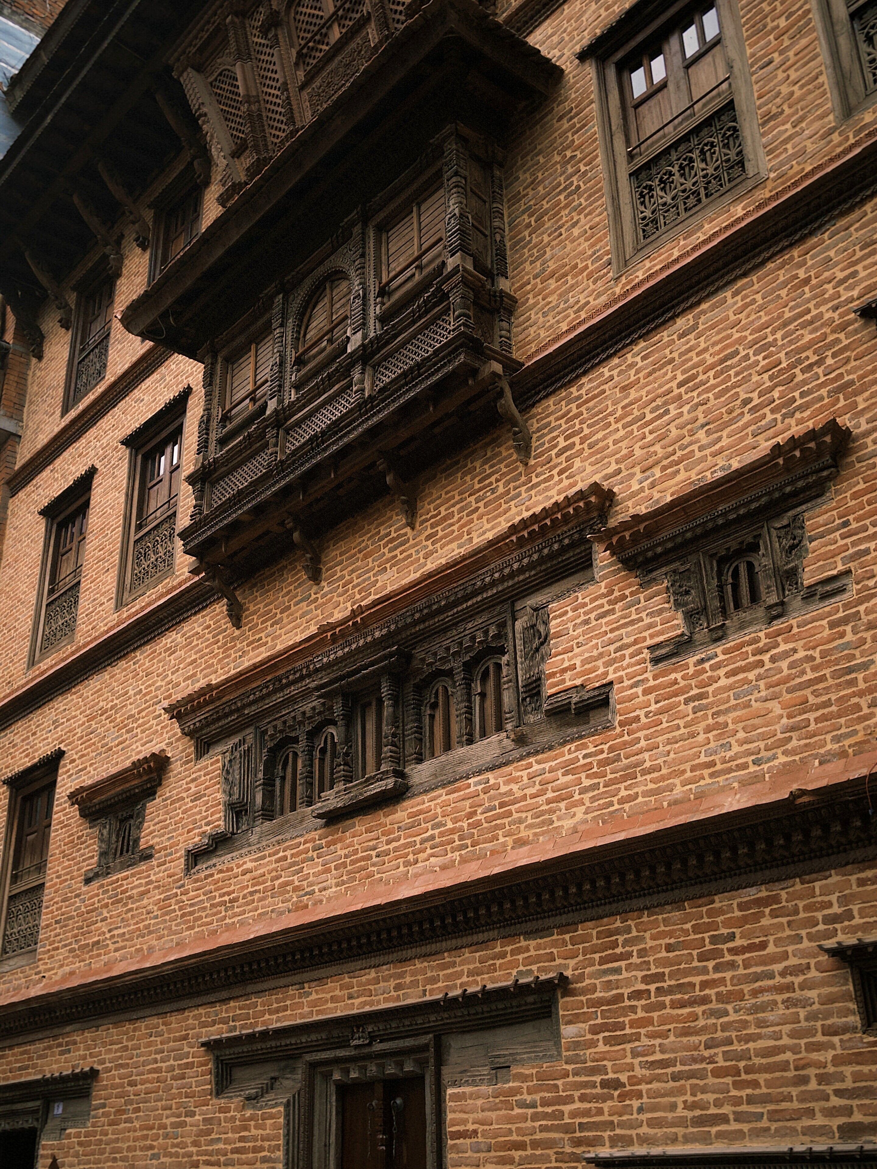 A multi-story building with traditional brickwork and ornate wooden balconies.