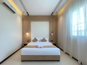A modern hotel room with a large bed, wooden paneling, and a large window with sheer curtains. - ALIAN PARK (Riyadh)