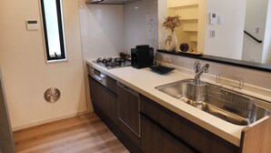 A modern kitchen with a stainless steel sink, a built-in oven, and a compact dishwasher.
