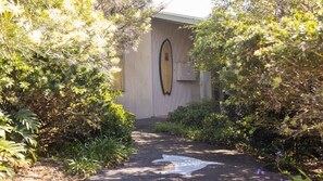 A pathway leading to a building with a surfboard design on the wall. - Magic Beach - Lifestyle Minnie Water (MINNIE WATER)