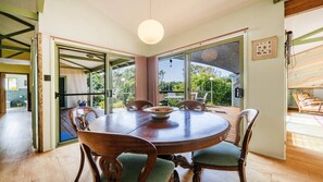 A dining area with a round table, chairs, and a view of the outdoors.