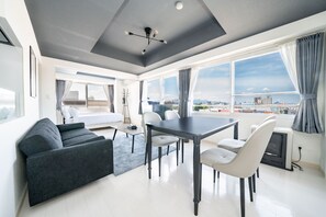 A modern living room with a dining area, large windows, and a city view. - HILLSGARDEN 405 (Sapporo)