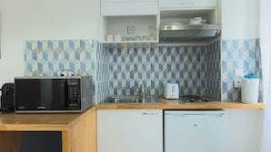A compact kitchen with a microwave, toaster, sink, and dishwasher. - Studio 2P Roland Garros/Parc des Princes (Boulogne-Billancourt)
