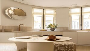 Une cuisine moderne avec une table de salle à manger ronde, un four encastré et une fenêtre offrant une belle vue.