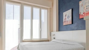 Ein Schlafzimmer mit einem Bett, einer Schiebetür und zwei Wandbildern.